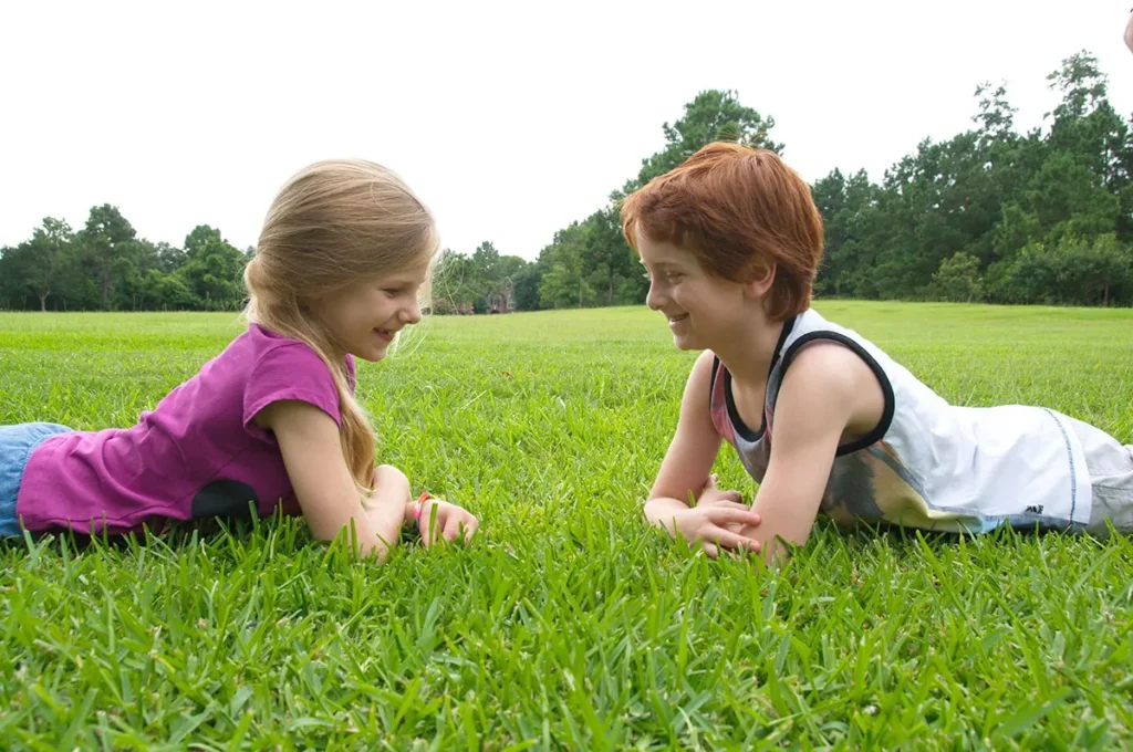 Two kids lying on the lawn